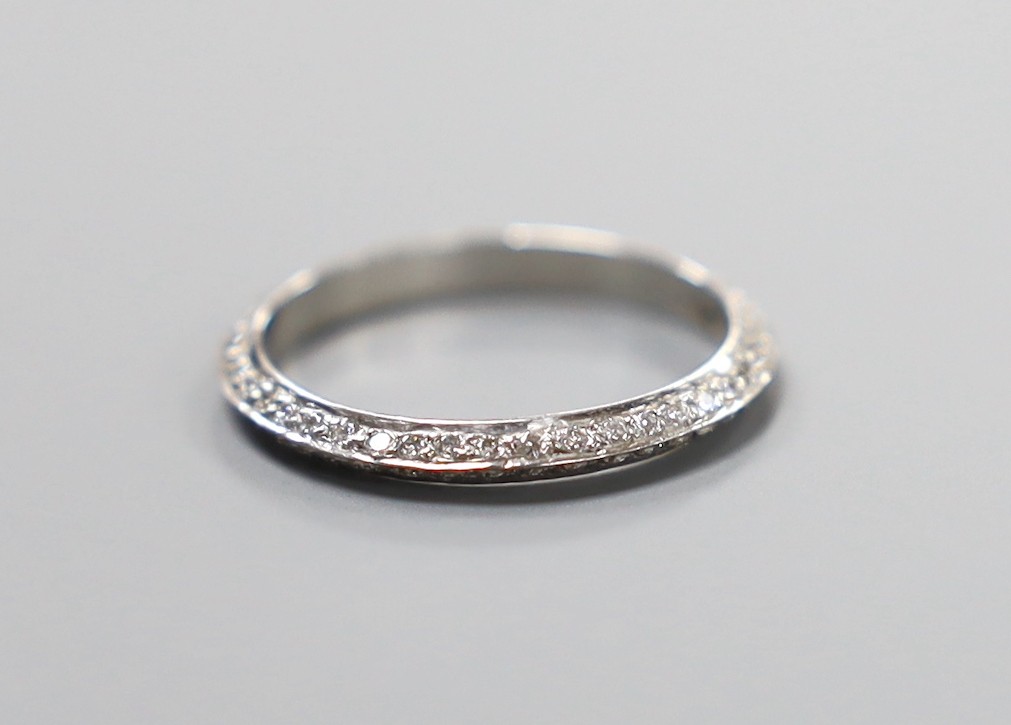 A modern white metal (tests as platinum) and two row diamond chip set full eternity ring, size L, gross weight 1.9 grams.
